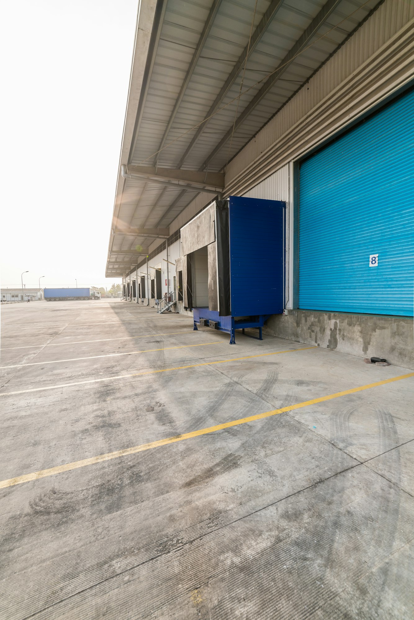 Vertical shot of a warehouse with blue garage doors at daytime
